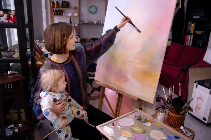 Juulia Kääriä maalaamassa ateljeessaan lapsensa Taiton kanssa, 2024, kuvaaja Pyry Kääriä