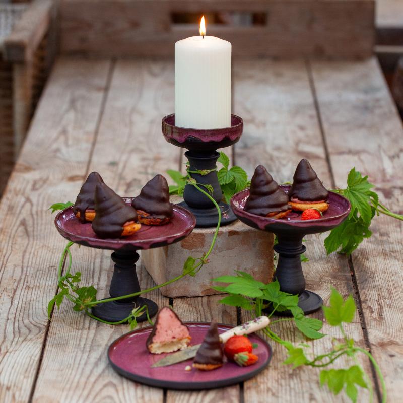 Drejade små kakfat, som kan användas även för blockljus. Svart stengodslera.