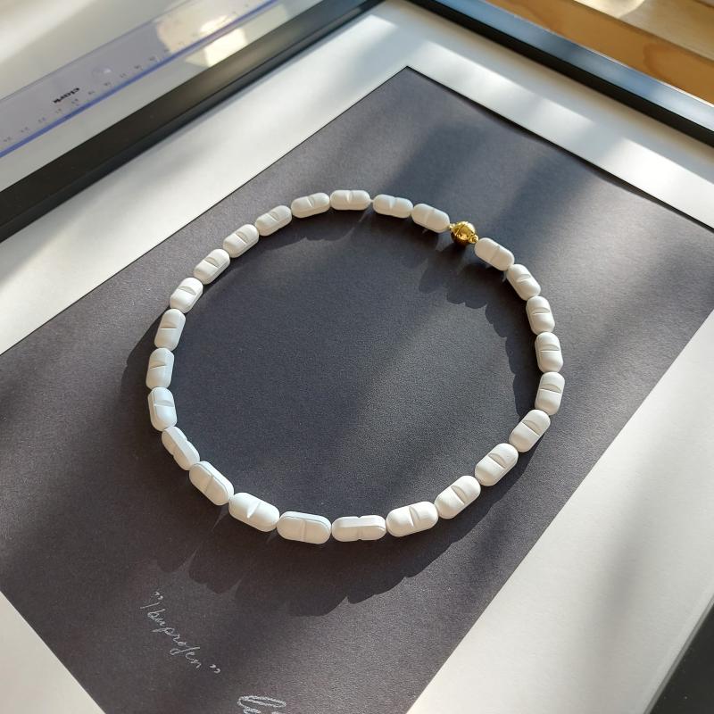 Korukunst, "Ibuprofen", halsband av Ibuprofen, silkestråd och förgyllt magnetlås i silver, 45cm, 2022