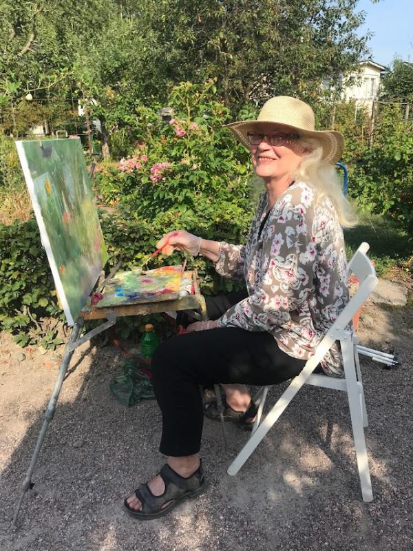 Aulikki työskentelee öljyväreillä siirtolapuutahassa 